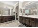 Bathroom featuring double sinks, dark wood cabinets, and a separate shower area at 12002 Angle Pond Ave, Windermere, FL 34786