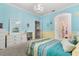 Charming bedroom with blue and yellow accents, featuring a dresser and multiple entryways at 12002 Angle Pond Ave, Windermere, FL 34786