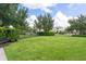Well-maintained common lawn area with lush green grass, mature trees, and a bench for relaxation at 12002 Angle Pond Ave, Windermere, FL 34786