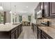 Well-equipped kitchen with dark wood cabinetry, stainless steel appliances, and granite countertops at 12002 Angle Pond Ave, Windermere, FL 34786