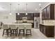 Modern kitchen featuring stainless steel appliances, a center island with bar seating, and dark wood cabinetry at 12002 Angle Pond Ave, Windermere, FL 34786