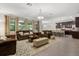Spacious open-concept living room with a view of kitchen and large windows allowing natural light at 12002 Angle Pond Ave, Windermere, FL 34786