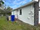 Side exterior of a white house with a stone chimney and a fenced-in yard under a blue sky at 1328 Highland Cir, Kissimmee, FL 34744