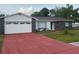 Charming single-story home with a red driveway, grey stone accents, and a two-car garage at 1328 Highland Cir, Kissimmee, FL 34744