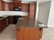 Spacious kitchen features wood cabinets, granite countertops, stainless steel appliances, and an island at 1328 Highland Cir, Kissimmee, FL 34744