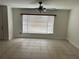 This living room features tiled floors, a ceiling fan, natural light, and neutral walls at 1328 Highland Cir, Kissimmee, FL 34744