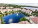 Aerial view of yellow buildings with red tile roofs surrounding a lake at 1400 Lake Shadow Cir # 10105, Maitland, FL 32751