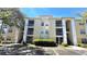 Three-story condo building with yellow siding, white trim, and exterior stairs and patios at 1400 Lake Shadow Cir # 10105, Maitland, FL 32751