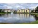 Exterior view of yellow buildings reflecting off the lake with a fountain at 1400 Lake Shadow Cir # 10105, Maitland, FL 32751
