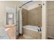 Inviting bathroom with a soaking tub, tiled walls, and view of the bedroom through an open door at 14645 Tullamore Loop, Winter Garden, FL 34787