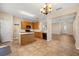 Spacious kitchen boasts an island, wooden cabinets and a view to the entry and a combined living and dining room at 14645 Tullamore Loop, Winter Garden, FL 34787