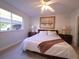 Comfortable bedroom with ceiling fan, two dressers, painting and a large window at 1600 W Lake Parker Dr # D5, Lakeland, FL 33805