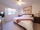 Bedroom featuring a ceiling fan, large window and neutral carpet at 1600 W Lake Parker Dr # D5, Lakeland, FL 33805