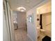 Hallway view leading to a bathroom with a shower/tub combination and white tiled floors at 1600 W Lake Parker Dr # D5, Lakeland, FL 33805