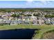 Aerial shot of the neighborhood showcasing the home's prime location, lake view, backyard pool, and well-maintained surroundings at 16781 Meadows St, Clermont, FL 34714