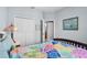 Cozy bedroom showcasing a colorful patchwork quilt, closet doors, and ensuite access at 16781 Meadows St, Clermont, FL 34714