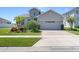 Inviting front exterior with a brick driveway, lush landscaping, and a two-car garage at 16781 Meadows St, Clermont, FL 34714