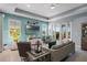 Comfortable living room with a large TV, sliding glass doors to the lanai, and views of the lush backyard at 16781 Meadows St, Clermont, FL 34714