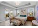 Serene main bedroom with a tray ceiling, neutral tones, and access to the outdoor patio at 16781 Meadows St, Clermont, FL 34714