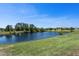 Lush backyard with a tranquil pond view, showcasing the home's serene natural surroundings at 16781 Meadows St, Clermont, FL 34714