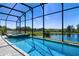 Sparkling pool with screened-in lanai overlooking serene waterfront views at 16781 Meadows St, Clermont, FL 34714