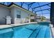 Screened-in pool area features a grill, chairs, and view of the backyard at 16781 Meadows St, Clermont, FL 34714