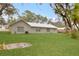 Large backyard view showcasing a home with a metal roof and lush lawn at 1704 15Th St, Orange City, FL 32763