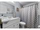 Well-lit bathroom featuring a shower with patterned curtain and vanity with storage space at 1969 La Rue Ave, Deltona, FL 32725