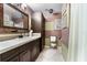 Clean bathroom featuring dark wood cabinets, a tiled vanity, and decorative walls at 1969 La Rue Ave, Deltona, FL 32725