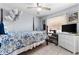 Calm bedroom featuring a ceiling fan and bright window with sewing machine and TV on a dresser at 1969 La Rue Ave, Deltona, FL 32725