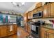 Well-lit kitchen with wooden cabinets, granite countertops, and stainless steel appliances at 1969 La Rue Ave, Deltona, FL 32725