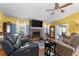 Inviting living room featuring a brick fireplace, hardwood floors, and natural light from the windows at 1969 La Rue Ave, Deltona, FL 32725