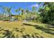 Expansive backyard features mature trees, a playset, and a covered patio, creating an inviting outdoor space at 245 Country Circle E Dr, Port Orange, FL 32128
