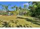 Spacious backyard featuring a unique playground structure, lush lawn, and pergola-covered dining area at 245 Country Circle E Dr, Port Orange, FL 32128