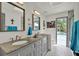 Bathroom with double sinks, granite countertops, a tile floor and access to the outdoor pool at 245 Country Circle E Dr, Port Orange, FL 32128