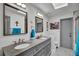 Bathroom featuring a double sink vanity, framed mirrors, modern fixtures, and gray paint at 245 Country Circle E Dr, Port Orange, FL 32128