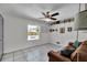 The bedroom area offers tile flooring, a ceiling fan, and natural light from the window, and an inviting couch at 245 Country Circle E Dr, Port Orange, FL 32128