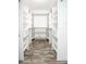 Walk in closet with white shelving and drawers plus hardwood floors at 245 Country Circle E Dr, Port Orange, FL 32128