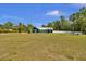 Charming blue house with a large front yard, white fence, and tropical palm trees at 245 Country Circle E Dr, Port Orange, FL 32128