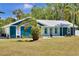 Charming home featuring textured accents and a metal roof, framed by a neatly maintained lawn at 245 Country Circle E Dr, Port Orange, FL 32128