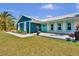 Charming blue home featuring a metal roof, colorful accents, and a well-manicured lawn at 245 Country Circle E Dr, Port Orange, FL 32128