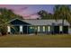 Lovely blue house with decorative stone details, bright accents, and evening sunset at 245 Country Circle E Dr, Port Orange, FL 32128