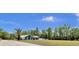 Exterior view features a charming home with lush landscaping and a spacious yard with beautiful palms at 245 Country Circle E Dr, Port Orange, FL 32128