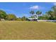 Charming blue house with a large front yard, white fence, and tropical palm trees at 245 Country Circle E Dr, Port Orange, FL 32128