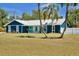 Charming blue home featuring a metal roof, colorful accents, and a well-manicured lawn at 245 Country Circle E Dr, Port Orange, FL 32128