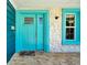 Close up of front door with turquoise trim, stone siding, and brick entryway at 245 Country Circle E Dr, Port Orange, FL 32128
