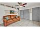 Cozy living room featuring a leather sofa, ceiling fan, and built-in shelving for ample storage at 245 Country Circle E Dr, Port Orange, FL 32128