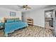 A cozy main bedroom features hardwood floors, ceiling fan, and a king bed dressed with blue comforter and matching end tables at 245 Country Circle E Dr, Port Orange, FL 32128