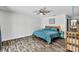 A cozy main bedroom features hardwood floors, ceiling fan, and a king bed dressed with blue comforter and matching end tables at 245 Country Circle E Dr, Port Orange, FL 32128