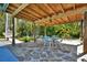 Outdoor dining area with wood pergola, stone flooring, table, and chairs offers a relaxing atmosphere at 245 Country Circle E Dr, Port Orange, FL 32128